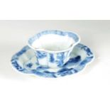 AN 18TH CENTURY CHINESE KANGXI BLUE AND WHITE SHAPED CUP AND SAUCER