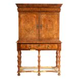 A WILLIAM AND MARY HERRING-BANDED BURR WALNUT CABINET ON STAND