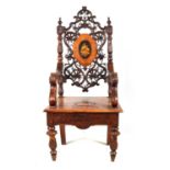 A 19TH CENTURY SWISS/BLACK FOREST CARVED WALNUT MUSICAL ARMCHAIR