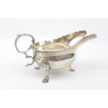 A Silver Georgian-style cream boat, the base inset with a silver sixpence dated 1745 12cm long,