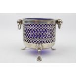 A Silver circular bowl with pierced side and blue glass liner on three pad feet, 7cm in Height,