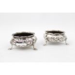 Pair of Mid Victorian Silver Floral embossed Open salts supported on pad feet, By William Hunter,