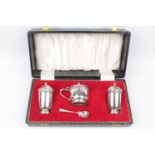 A boxed three-piece cruet set with spoon, Birmingham 1973. 130g total weight excluding blue glass