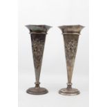 A good pair of Silver Edwardian oval spill vases, the fronts embossed with vases of flowers, 22cm in