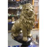 Pottery cast figure of a Lion, gold painted on black base, 40cm in Height