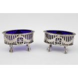 Pair of Oval Silver open salts with blue glass liners, pierced wreath design over paw feet London