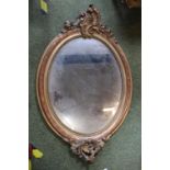 Very Ornate 19thC Oval Gilt Gesso framed mirror with Foliate decoration outside beaded border. 128 x