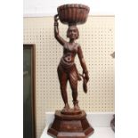 Large Anglo-Indian carved figure of a woman with woven basket over stepped base. 56cm in Height