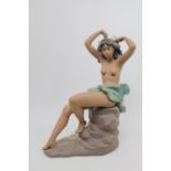 Nao Gres figure of a semi nude on rocky outcrop. 38cm in Height