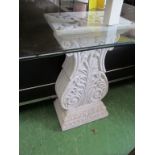 A glass top dining table on white classical pillars