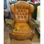 A leather wing armchair on tapered supports (in need of recovering)