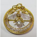 A pretty gold coloured brooch with bow top, filigree piercing and central diamond