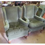 A pair of wing armchairs on carved cabriole legs