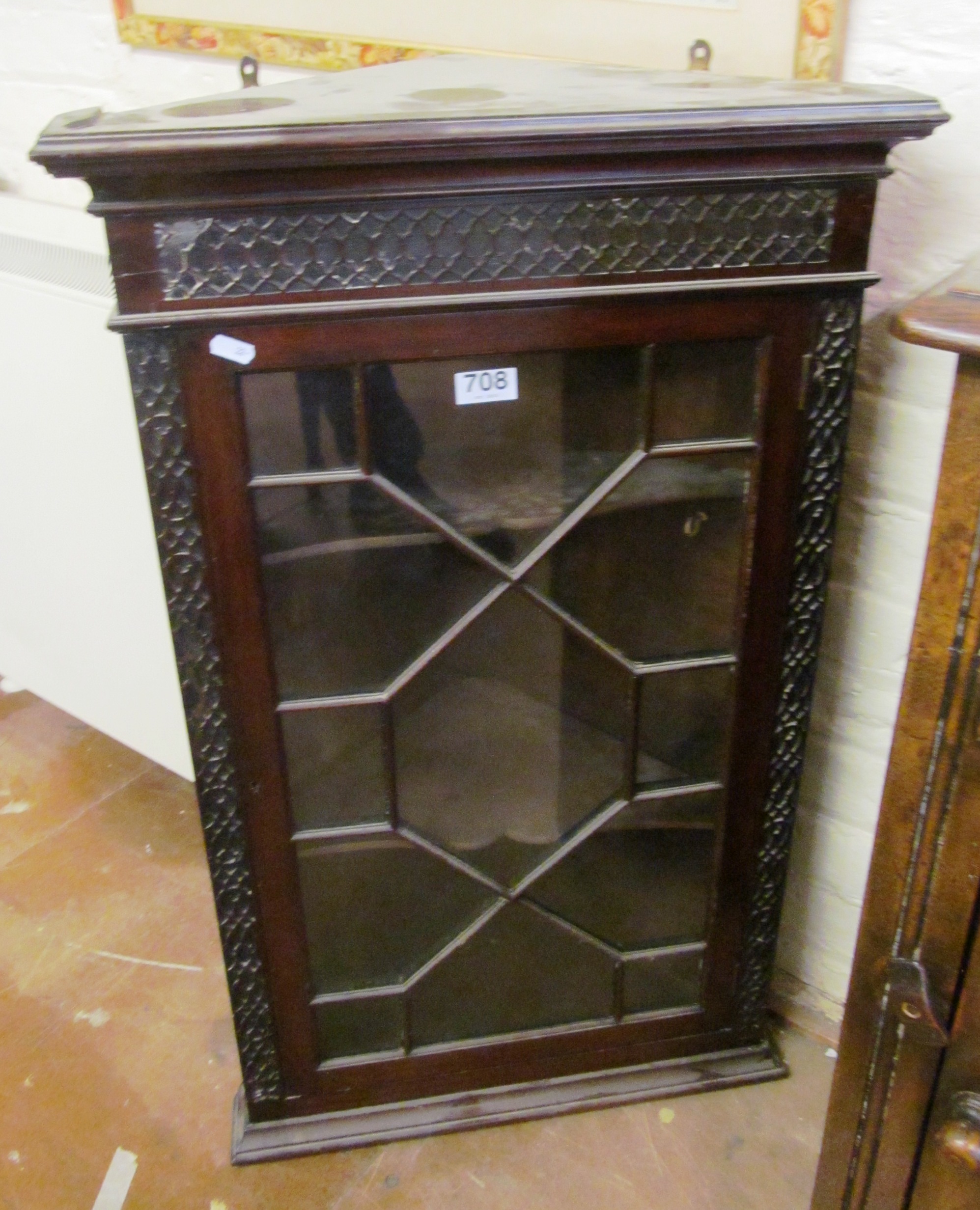 A small mahogany corner cabinet with single glazed door and blind fret decoration