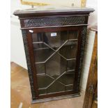 A small mahogany corner cabinet with single glazed door and blind fret decoration