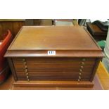 A coin cabinet with seven drawers