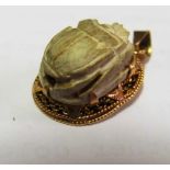 A scarab pendant in gold coloured mount