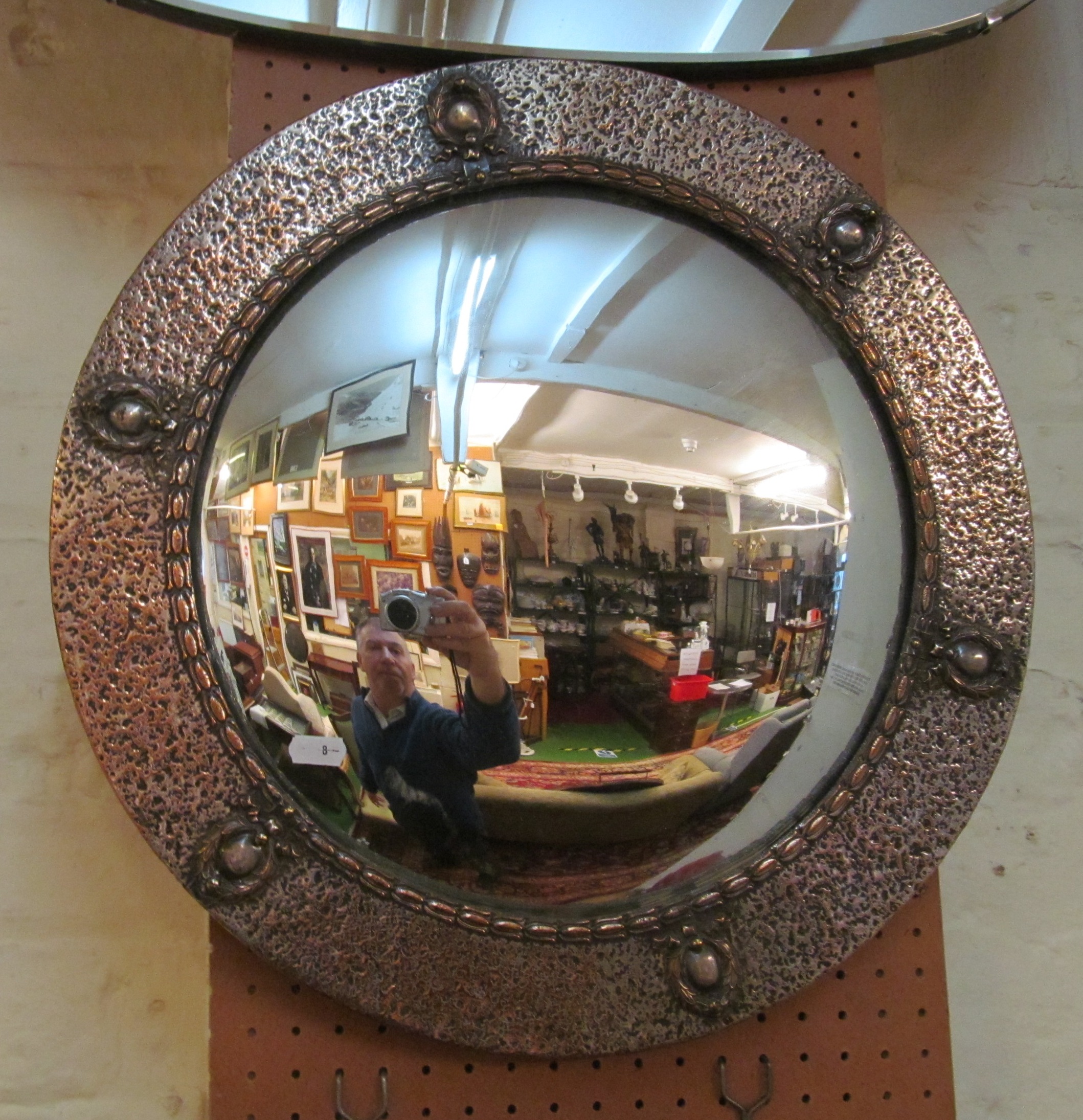 A beaten silvered framed convex mirror 18.5”