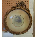 A circular gilt frame with photo of a child