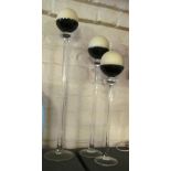 A set of three smoked and clear glass graduating tall candle holders