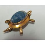 A 14k tortoise brooch with blue stone shell