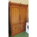An Edwardian satin walnut Arts and Crafts wardrobe with arched panelled doors of inlaid detail one