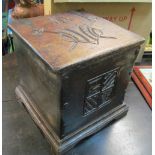 A carved oak square log box with heraldic motifs