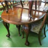 A Victorian extending mahogany dining table on carved cabriole legs with extra leaf and handle