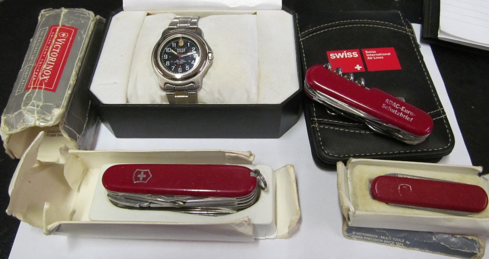 A Swiss Army watch, Notebook and calculator and three graduating penknives