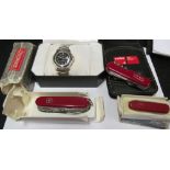 A Swiss Army watch, Notebook and calculator and three graduating penknives