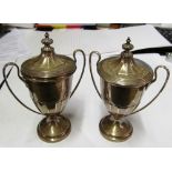 A pair of silver urn shaped lidded trophies (one slightly dented)