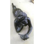 A bronze nude lady lying on her front with shell