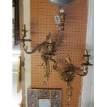 A pair of gilt leaf design two branch wall lights