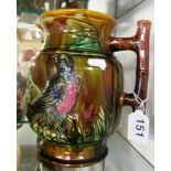 A large majolica jug with bamboo effect and raised bird design