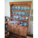 A pine dresser later delft rack on 19th Century base of seven drawers and cupboard