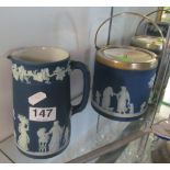 A Wedgwood Jasper deep blue biscuit barrel with plated lid and similar jug decorated classical