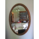 An oval gilt mirror