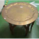 A Middle Eastern brass tray on folding stand