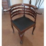 A mahogany corner chair with shaped back rail and curved arms on cabriole legs