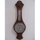 A barometer/thermometer in oak case