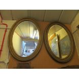 A pair of oval framed gilt mirrors