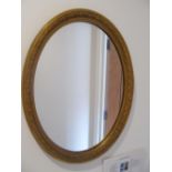 An oval gilt mirror