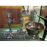 A pair of silver-plated tapered candlesticks with floral bases and a plated bowl