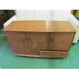 An Ercol sideboard three cupboard doors above two drawers