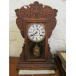 An American mantle clock in carved oak case with glass door revealing pendulum 53cms high