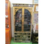 A chinoiserie black and gilt cabinet, two glazed doors and three drawers