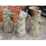 Three concrete pig band garden ornaments