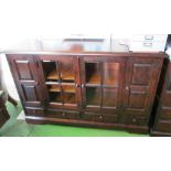 A similar sideboard with two glazed central doors flanked by two cupboard doors above four small