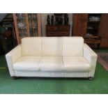 A cream leather three seater settee