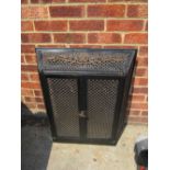A metal fire grate cover with two hinged doors